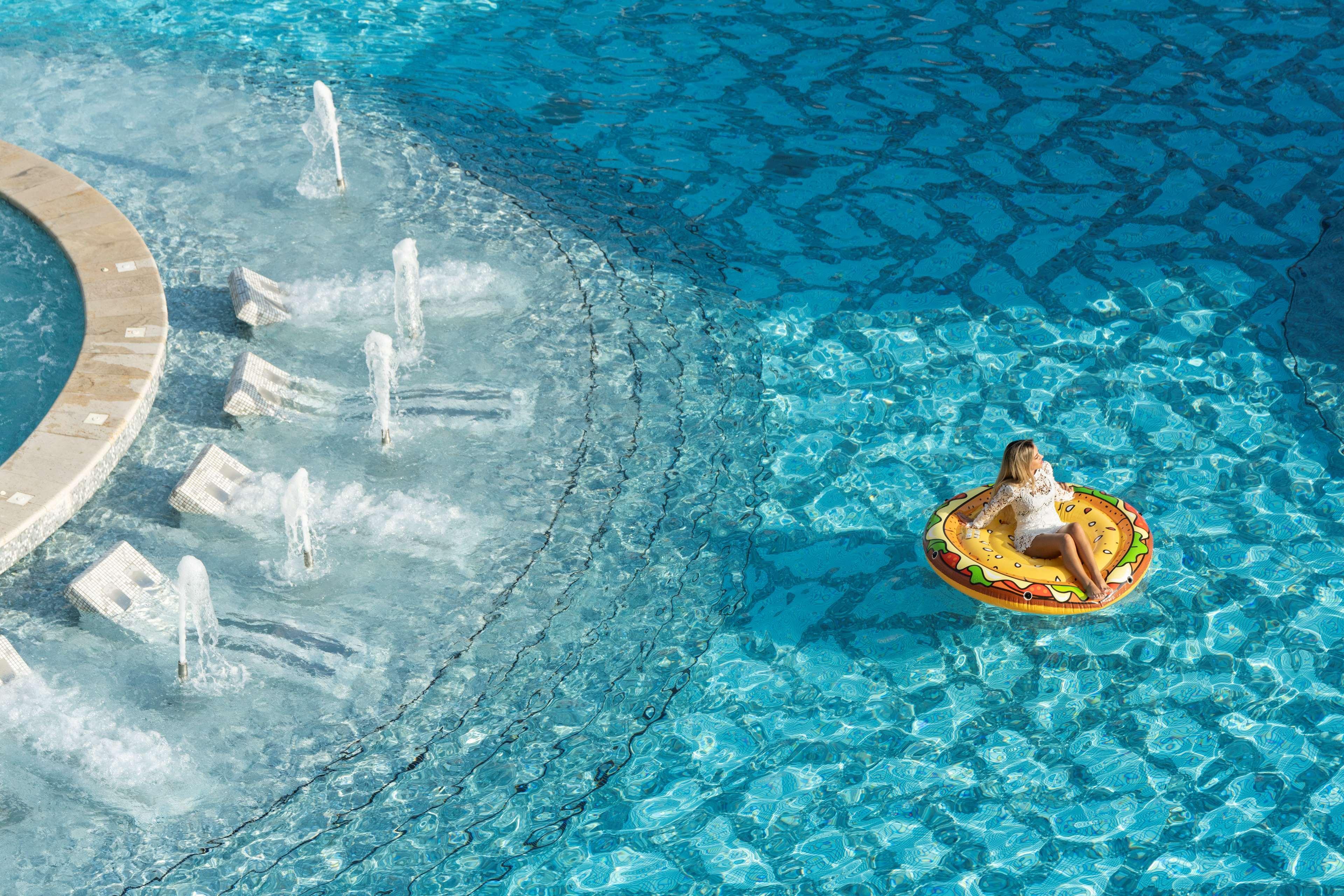 Hilton Doha The Pearl Hotel Bagian luar foto A woman on a hamburger float